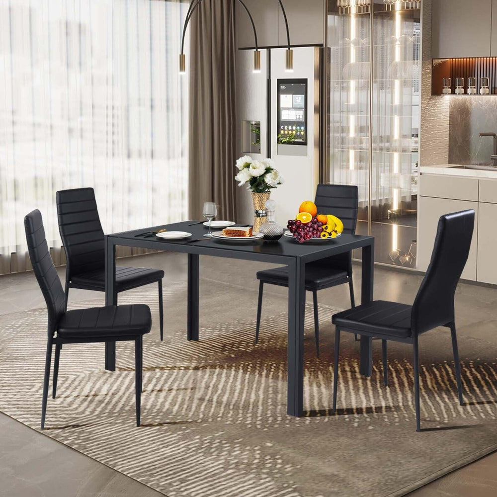 Modern dining set featuring four black leather chairs with metal frames, ideal for dining rooms and elegant gatherings.