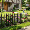 Decorative metal garden fence with fleur-de-lis finials, showcasing flowers in a landscaped yard for elegant outdoor.