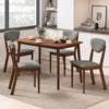Rectangular dining table with four ergonomic gray fabric chairs, perfect for a cozy breakfast nook or kitchen setting.