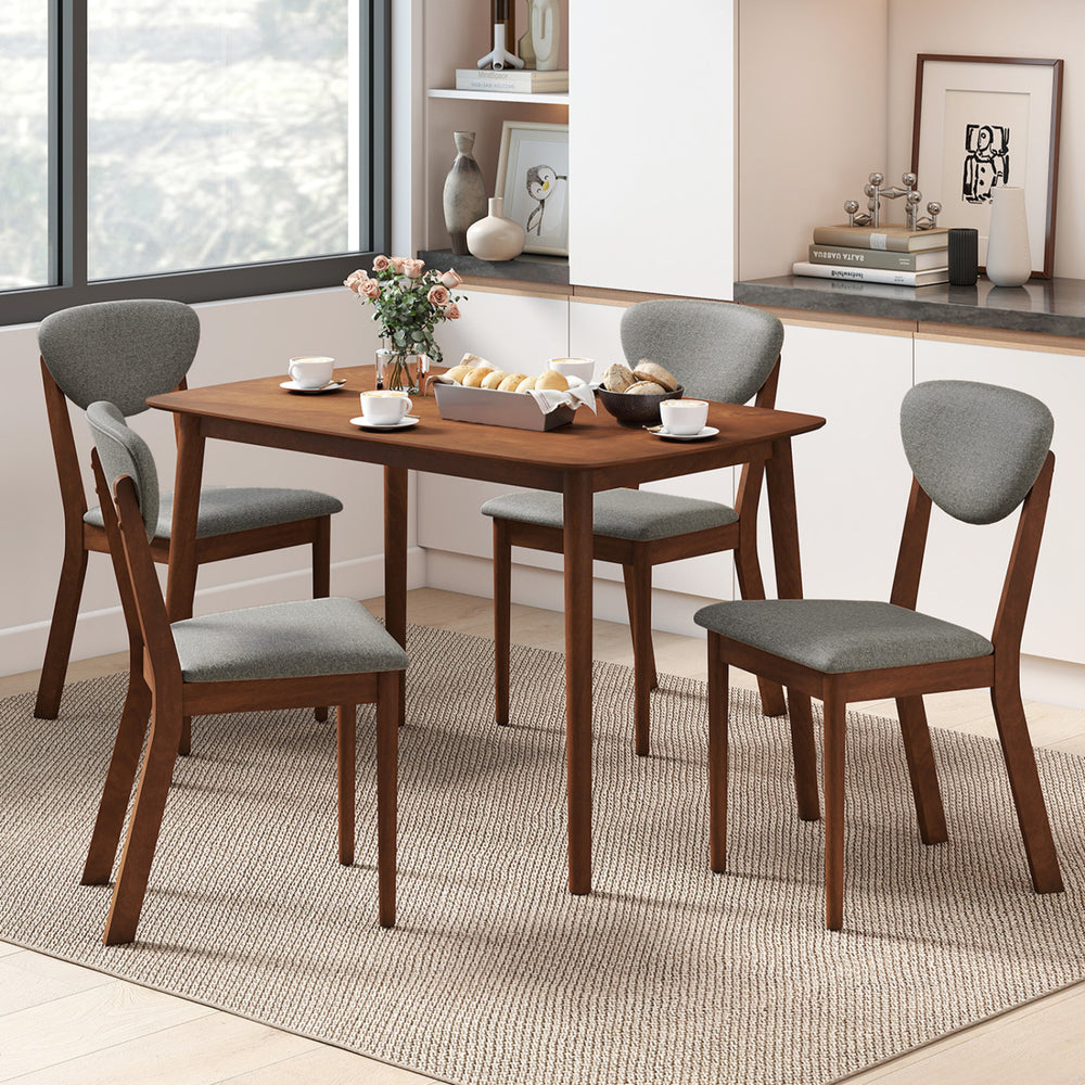 Rectangular dining table with four ergonomic gray fabric chairs, perfect for a cozy breakfast nook or kitchen setting.