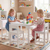 Kids playing at a white 5-piece table and chairs set made of solid rubber wood, perfect for activities in playrooms.