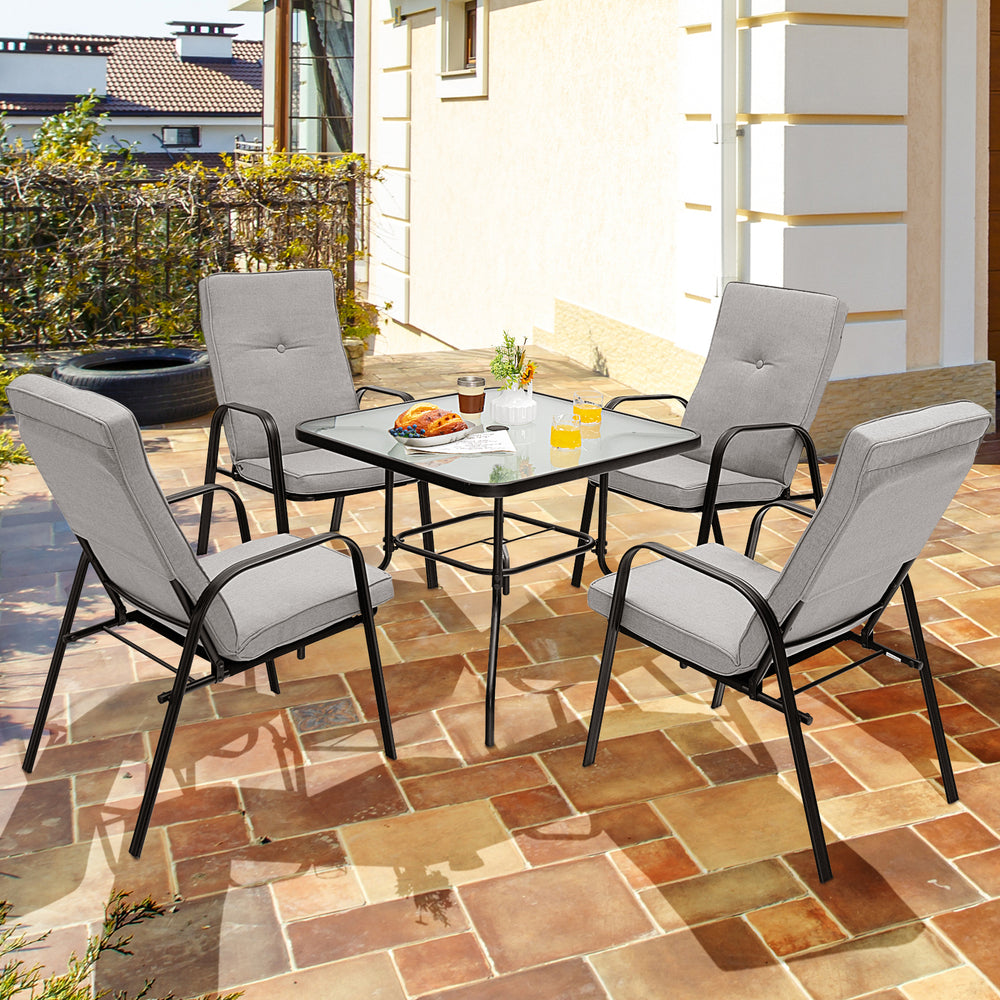 Outdoor dining set featuring a 35" tempered glass table and four stackable chairs with high-back cushions for comfort.