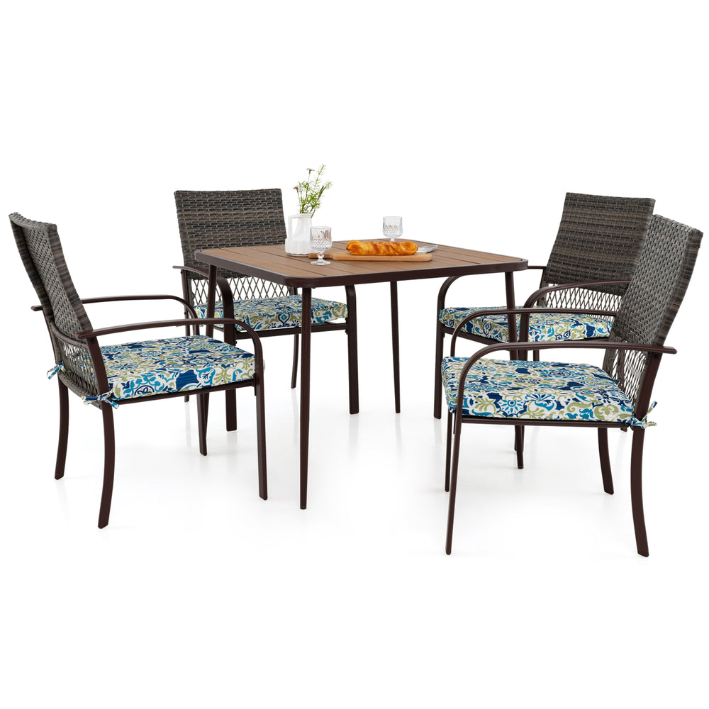 Square table with four cushioned rattan armchairs, perfect for outdoor dining in backyard or poolside settings.