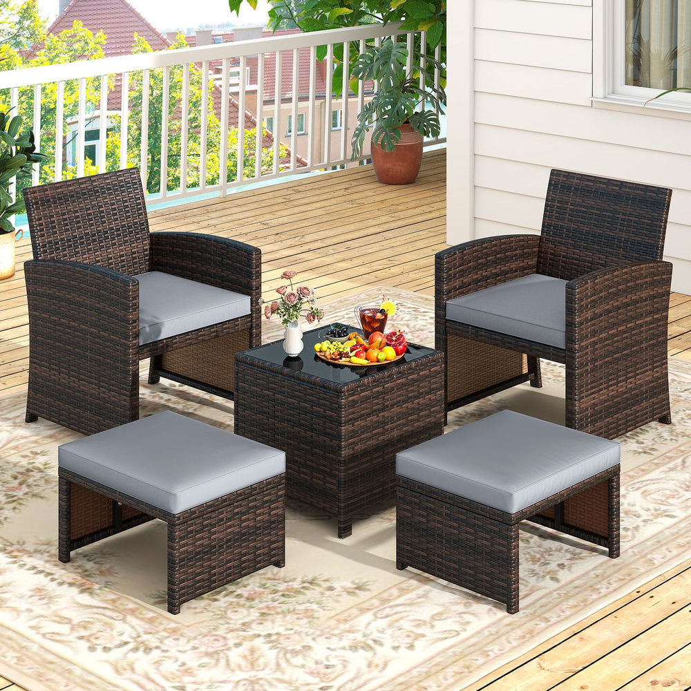 5-piece patio rattan furniture set featuring gray cushions, tempered glass coffee table, and versatile ottomans for outdoor use.