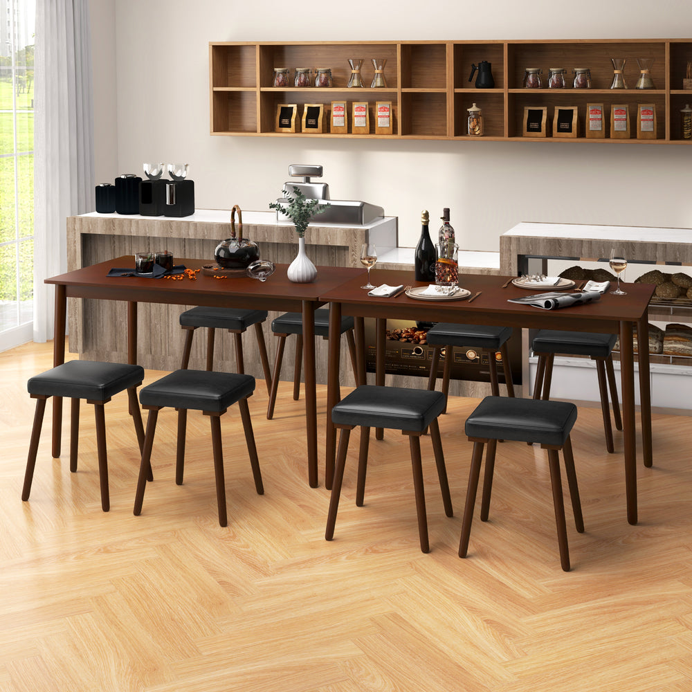 Compact upholstered stool with padded PU leather seat and rubber wood legs, designed for easy storage under the table.