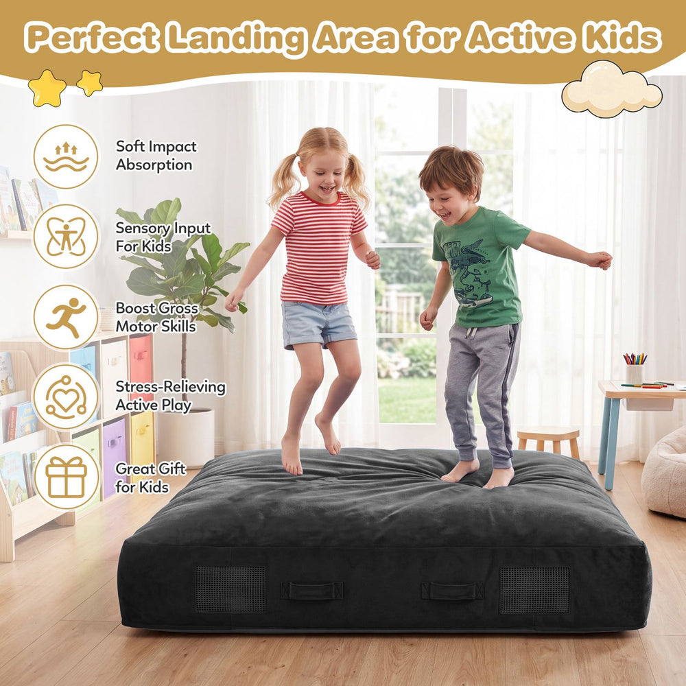 Kids jump on a 60-inch black crash pad with a soft velvet cover, perfect for sensory play and impact absorption.