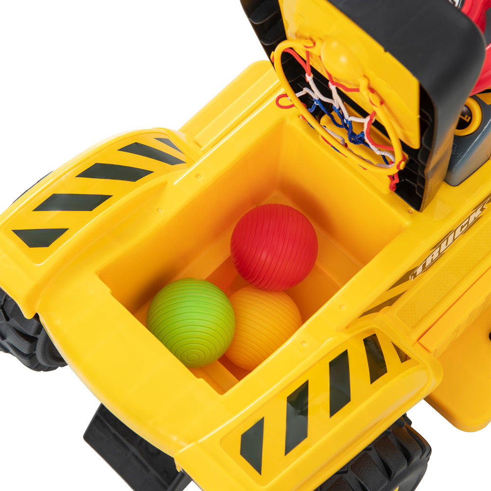 Yellow kids ride-on excavator with hidden storage and three colorful balls for fun basketball play.