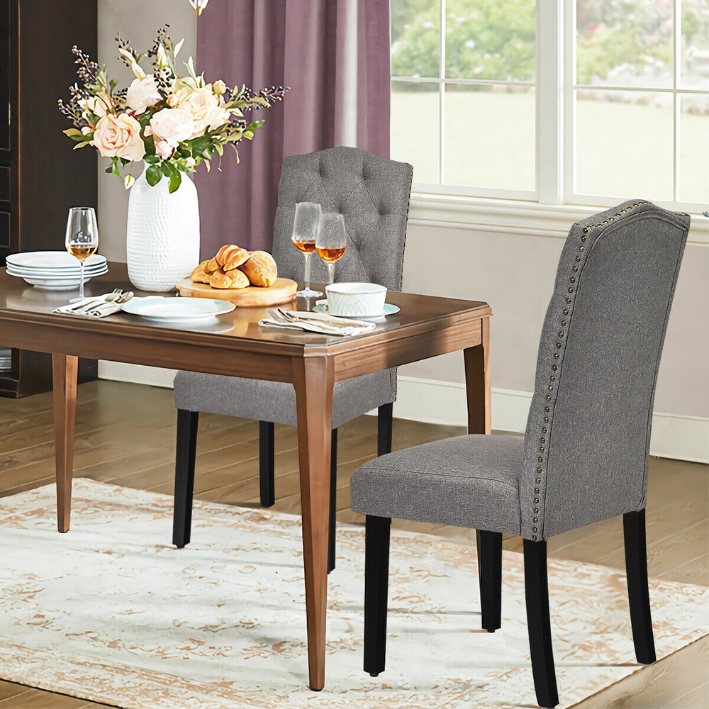 Tufted upholstered dining chairs in gray with rubberwood legs, perfect for home or café use, offering comfort and.