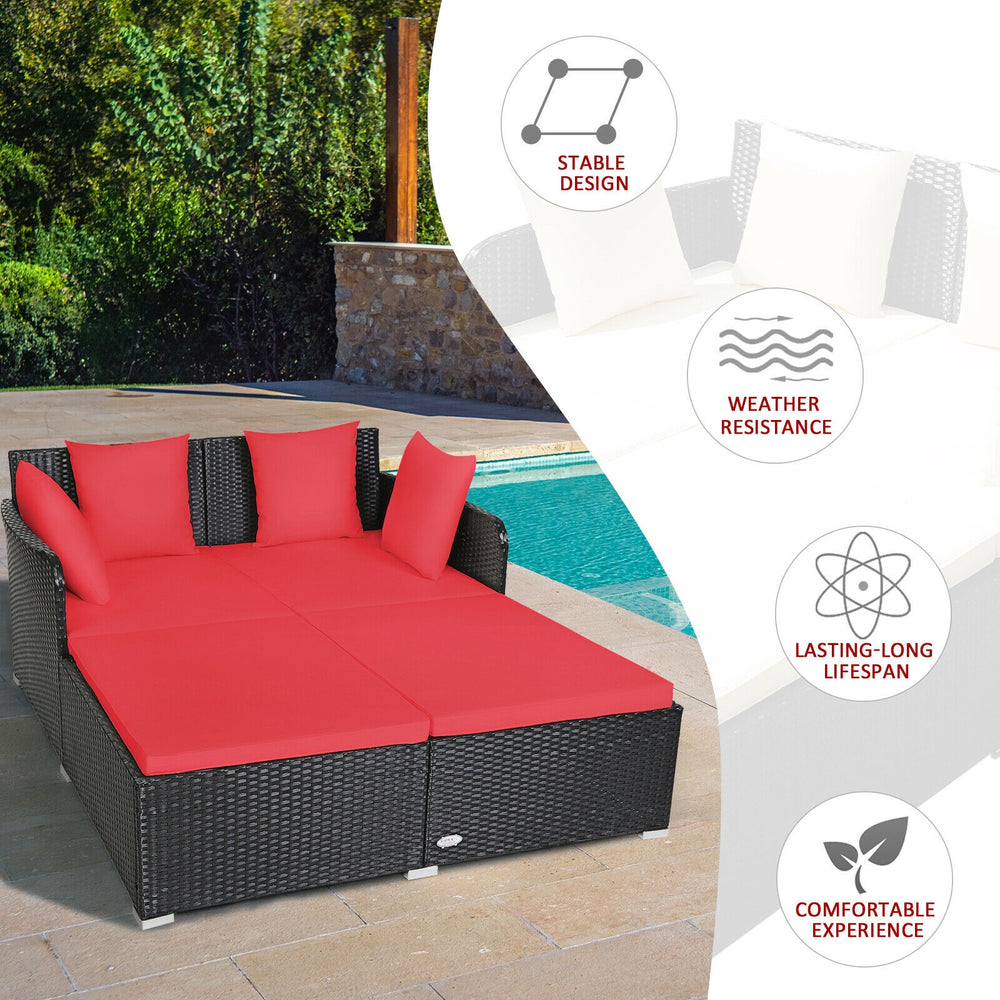 Spacious outdoor rattan daybed with red upholstered cushions, featuring a curved backrest and weather-resistant design.