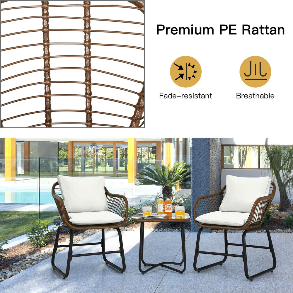 Cushioned armchairs and glass table from a 3-piece patio rattan bistro set for outdoor relaxation.