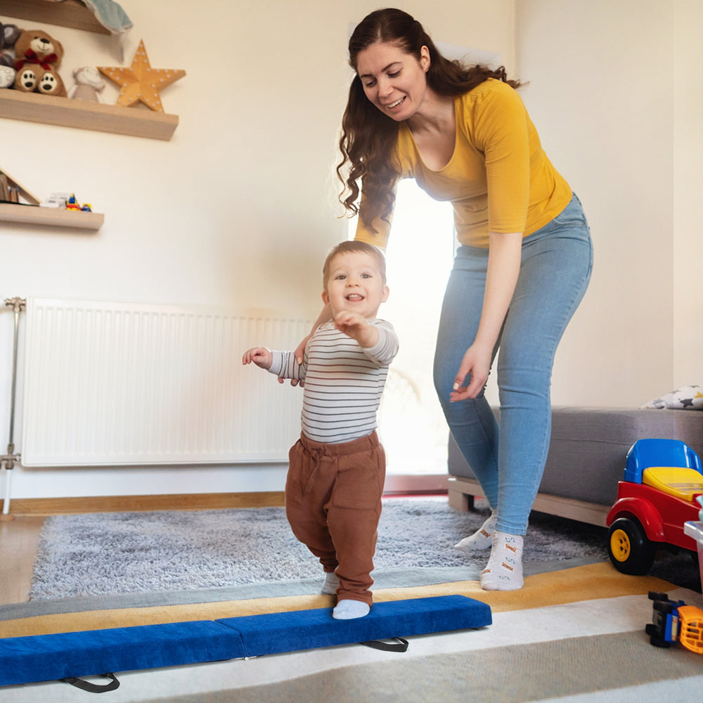 Child practicing on a blue folding balance beam with handles, designed for gymnasts to enhance balance and coordination.