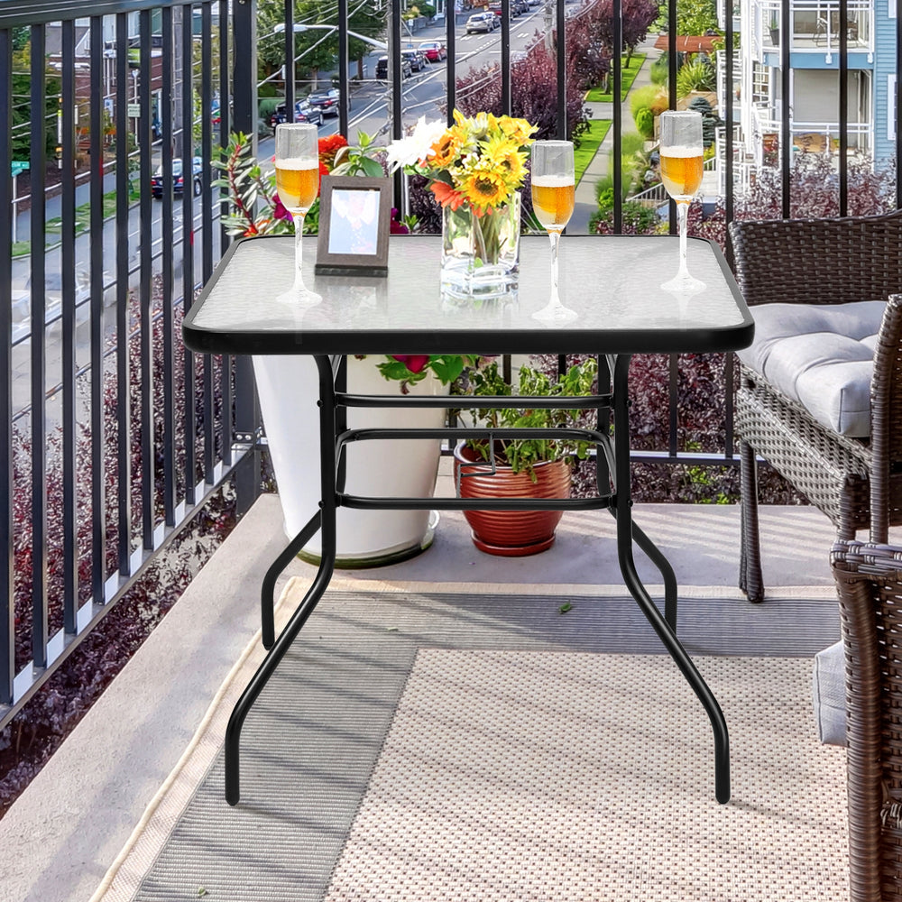 Black steel square table with tempered glass top, perfect for outdoor dining and umbrella use on a patio or balcony.