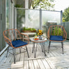 Two navy cushioned rattan armchairs and a glass-top table on a patio, perfect for outdoor relaxation.
