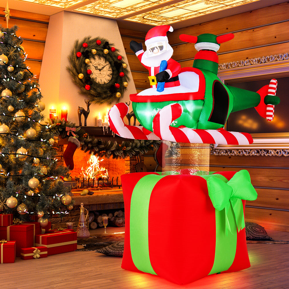 Santa Claus pilots a helicopter on a large red gift, featuring 3 LED lights for festive outdoor decoration.