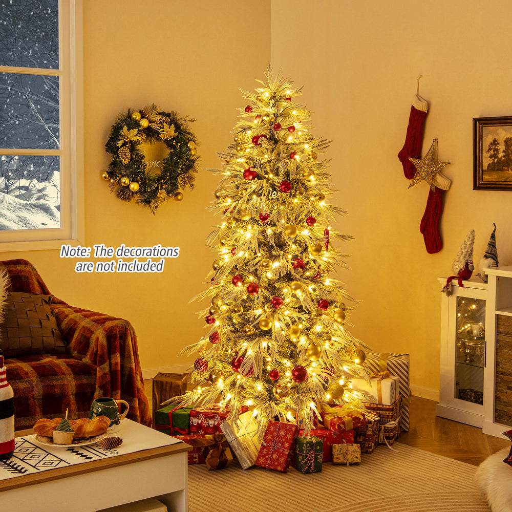 Realistic snow-flocked 6-foot artificial Christmas tree with warm white LED lights, set in a cozy holiday living room.
