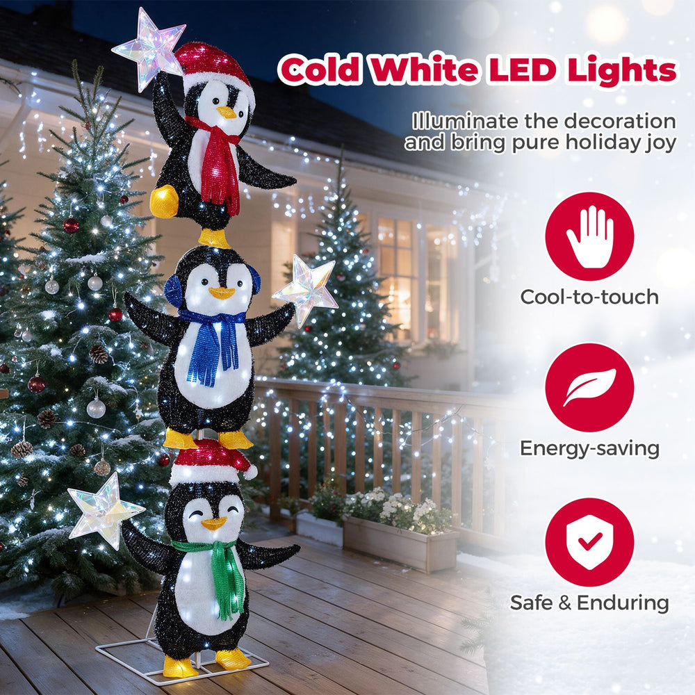 Three stacked penguins with cold white LED lights, wearing Christmas hats and scarves, add festive cheer to holiday decor.