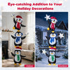 Three stacked penguins with Christmas hats and scarves, illuminated by cold white LED lights for festive outdoor decor.