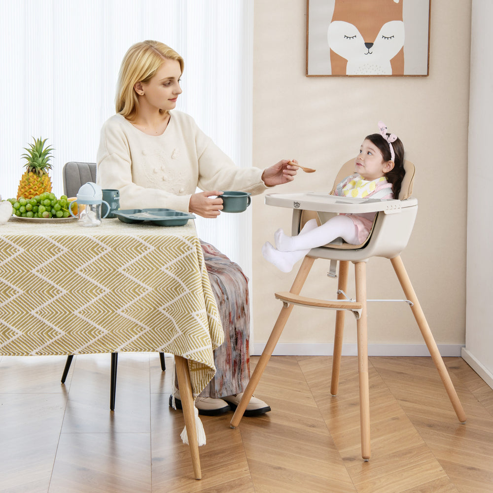 Convertible wooden highchair in light brown with adjustable legs, safety harness, and cozy PU cushion for mealtime.