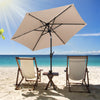 Tan 7.5 feet solar-powered patio umbrella with LED lights, crank handle, and push button tilt for optimal shade on the.