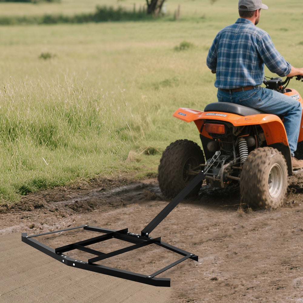 74-inch wide driveway drag tow behind landscape leveling rake, black, attached to an ATV for efficient soil leveling.