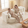 Curved 75.5-inch folding sofa bed in beige with two pillows, featuring teddy fleece for comfort and ergonomic support.