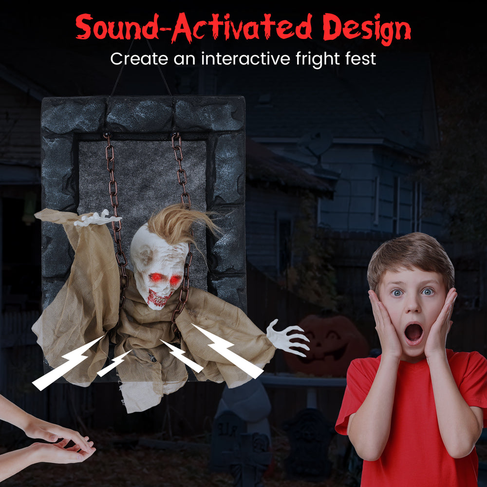 Hanging animated zombie prisoner decoration with sound-activated design, glowing red eyes, and terrifying features for.