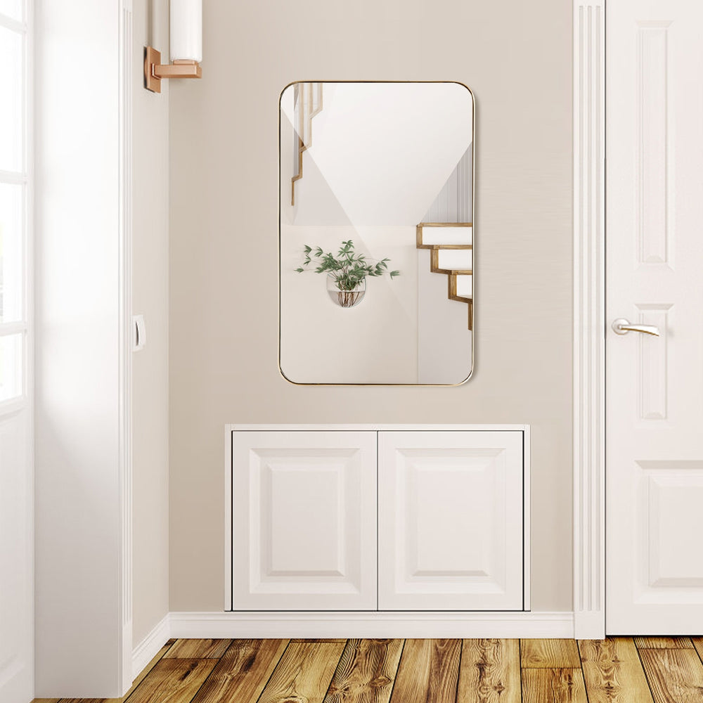 Wall-mounted rectangular mirror with a golden metal frame, ideal for bathrooms or hallways, offering a clear reflection.