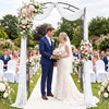 Heavy-duty metal garden arbor with curved roof, ideal for weddings and supporting climbing plants in outdoor settings.