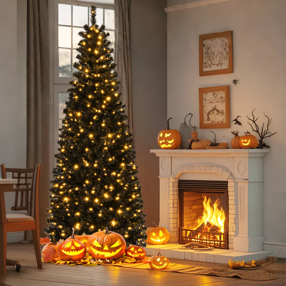 Pre-lit 7ft black artificial Christmas Halloween tree with warm white lights, surrounded by carved pumpkins by the.
