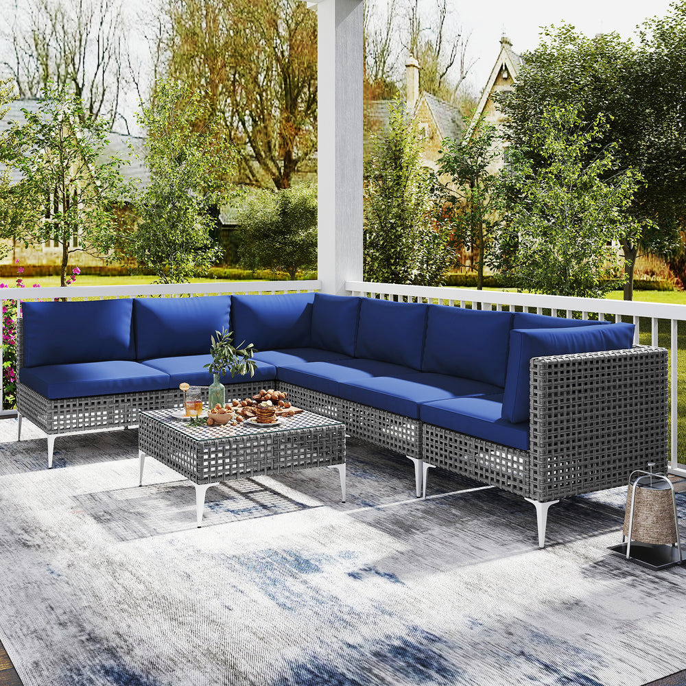 7-piece outdoor furniture set featuring navy cushions, PE rattan, and a tempered glass coffee table for backyard.