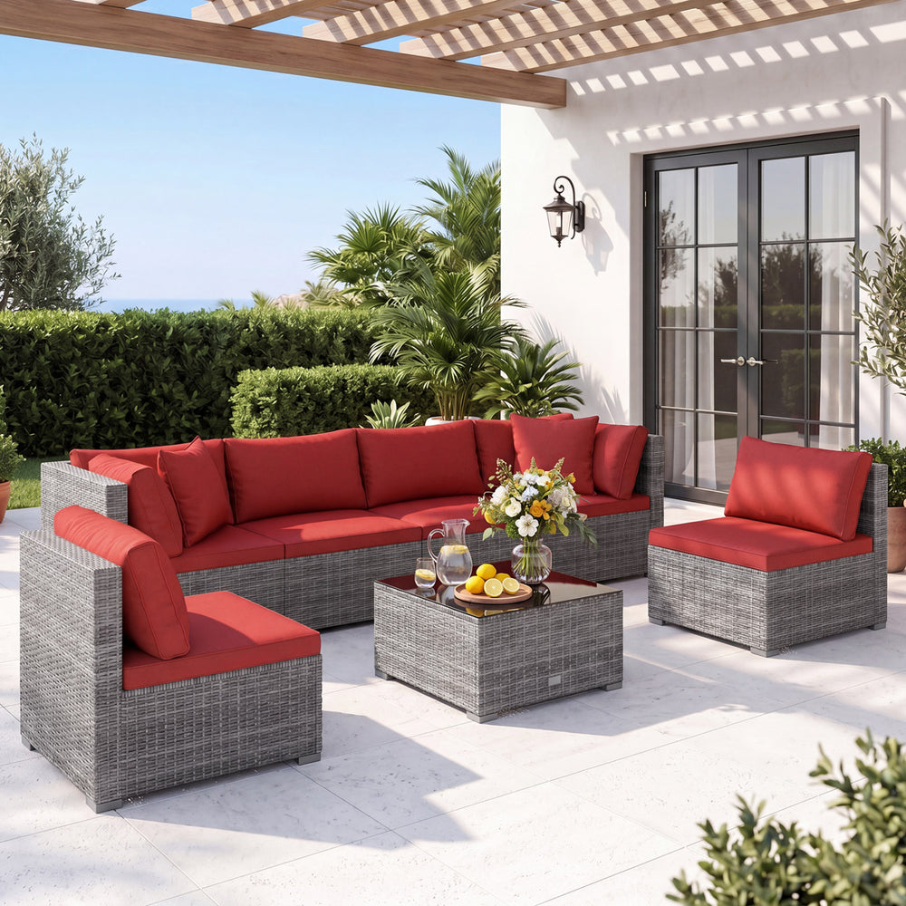 7-piece PE rattan patio set with red cushions and glass table, ideal for outdoor relaxation and versatile layouts.