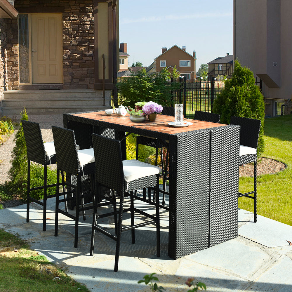 7-piece patio rattan wicker dining set featuring a table and 6 bar stools with cushions, ideal for outdoor dining.