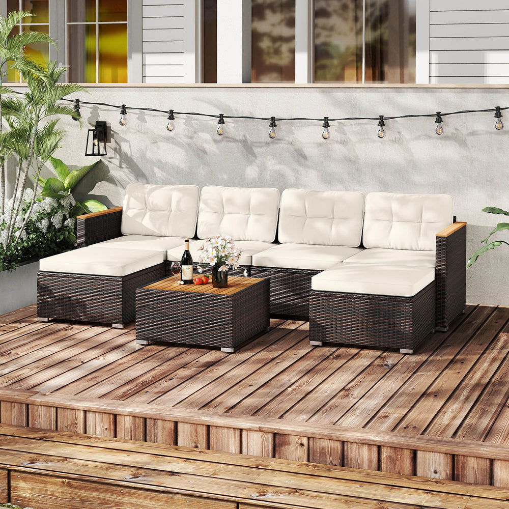 U-shaped wicker conversation set with white cushions and acacia wood armrests, perfect for backyard relaxation.