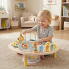 Toddler playing with the 7-in-1 Montessori activity table featuring a bead maze, xylophone, and shape sorter for.