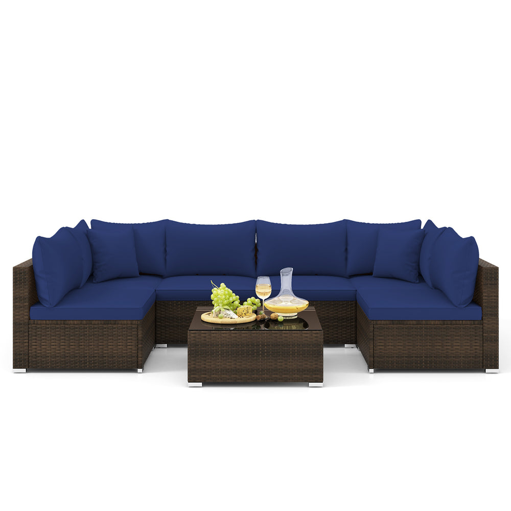Sectional sofa set with navy cushions, PE rattan material, and coffee table, perfect for outdoor patio relaxation.