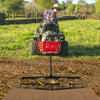 84-inch driveway drag tow behind landscape leveling rake, shown in use on a farm, effectively leveling soil and gravel.