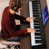 Foldable 88-key electric keyboard piano in black with dual speakers, ideal for music apps and easy storage.