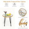 Round coffee table with tempered glass top and rattan design, perfect for outdoor patio use with cushioned chairs.