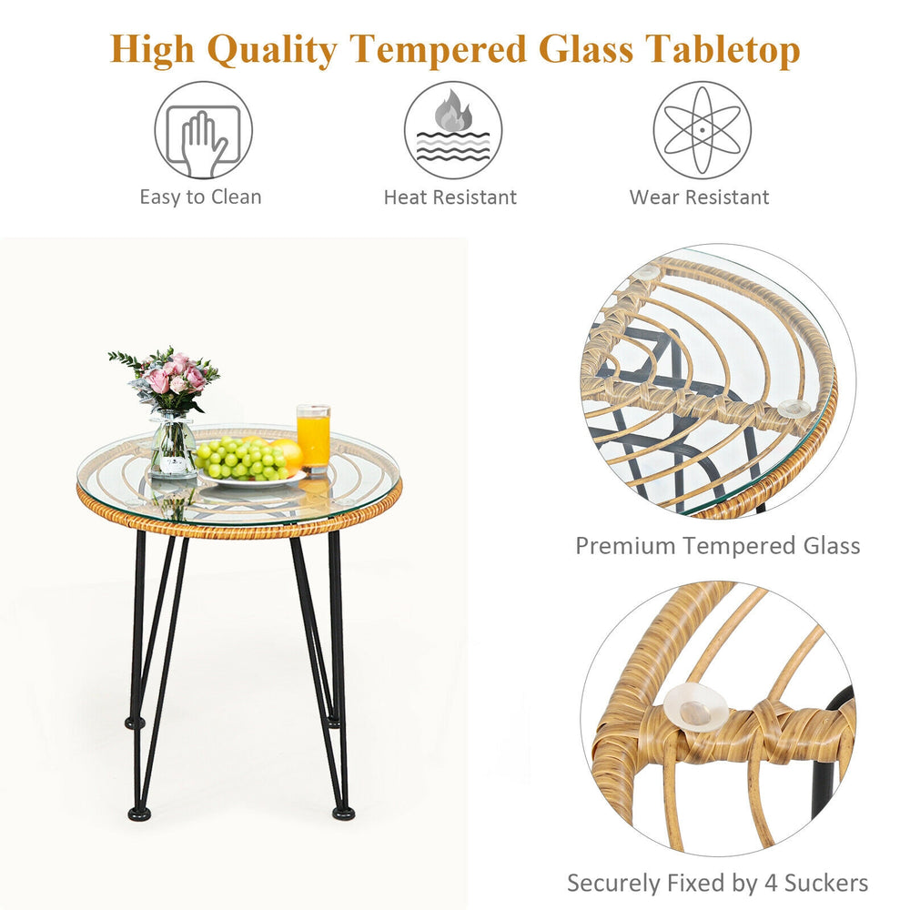 Round coffee table with tempered glass top and rattan design, perfect for outdoor patio use with cushioned chairs.