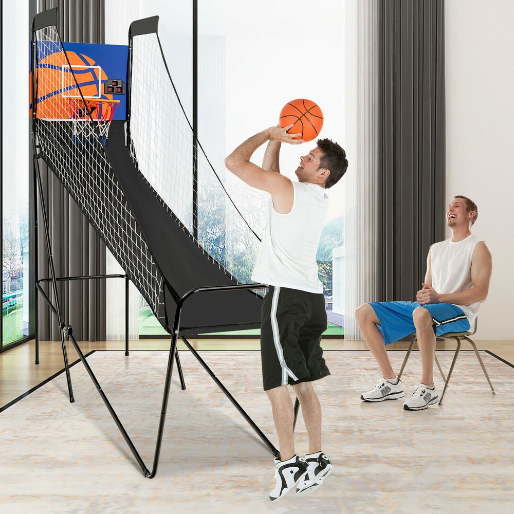 User enjoying the foldable single shot basketball arcade game with electronic scorer and three basketballs for fun.