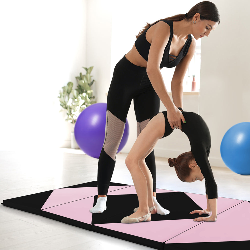 Folding gymnastics mat in black and pink, featuring high-density foam, ideal for fitness and kids' activities.