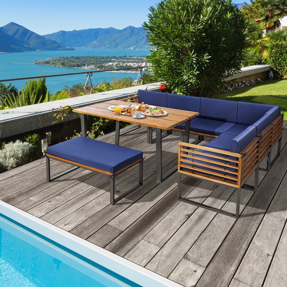 Patio dining set featuring acacia wood table and navy cushions, perfect for outdoor relaxation by the poolside.
