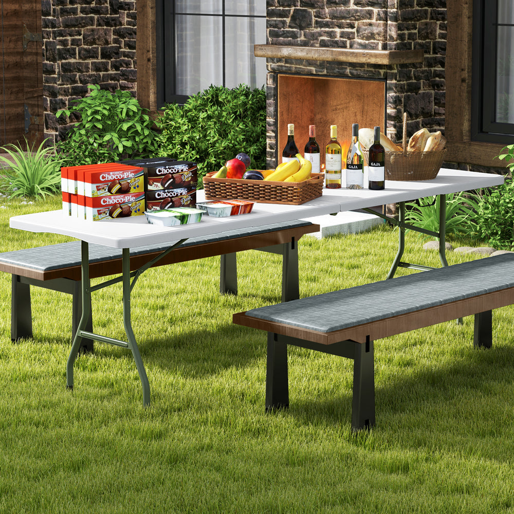 8 ft portable folding table with white HDPE tabletop, set up for outdoor use, ideal for picnics and gatherings.