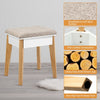 Cushioned stool with soft surface and solid wood legs, designed for comfort and stability in a vanity table set.