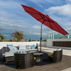 Dark red 10' solar LED lighted patio umbrella with tilt adjustment, set up for outdoor shading and evening ambiance.