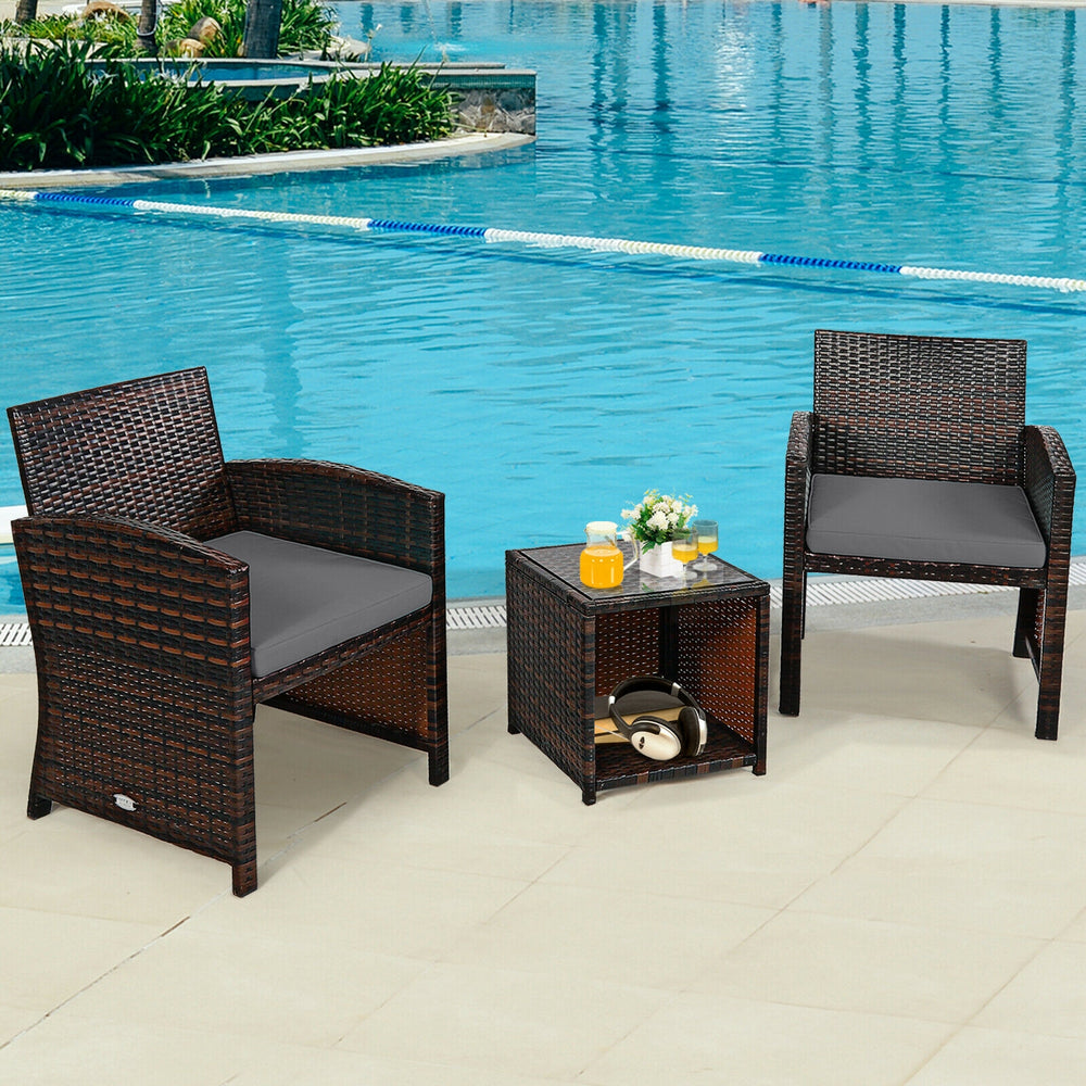 3-piece PE rattan wicker furniture set with gray cushions, featuring two chairs and a coffee table, ideal for poolside.