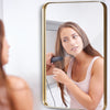 Rectangular wall-mounted mirror with a golden metal frame, ideal for bathrooms and living rooms, showcasing a clear.