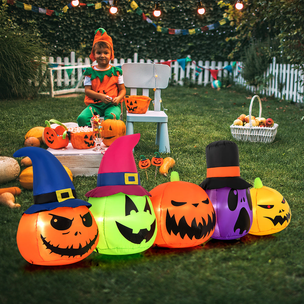 Inflatable pumpkin patch family with witch hats, featuring bright LED lights, perfect for Halloween yard decoration.