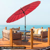9-foot round patio umbrella in wine color with fiberglass ribs, tilted for sun protection on a deck by the water.