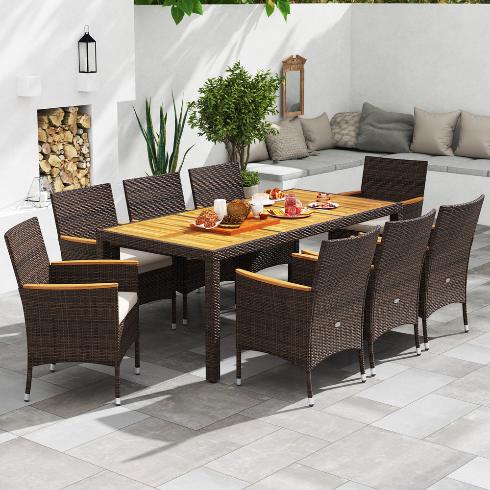 9-piece outdoor dining set featuring an acacia wood table top and brown PE rattan chairs with cushions for comfort.